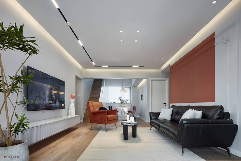 在这个空间中抢眼的莫过于沙发背景墙这一抹橙，低调沉稳中透着气质感，让整个空间镀上了偏复古的基调。
