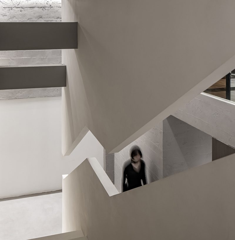 设计师遵循柯布西耶的建筑法则，在阶梯的侧面打造长窗，压低层高，弱化功能性，借由错位的视觉导向，诱发来访者的探究欲望。