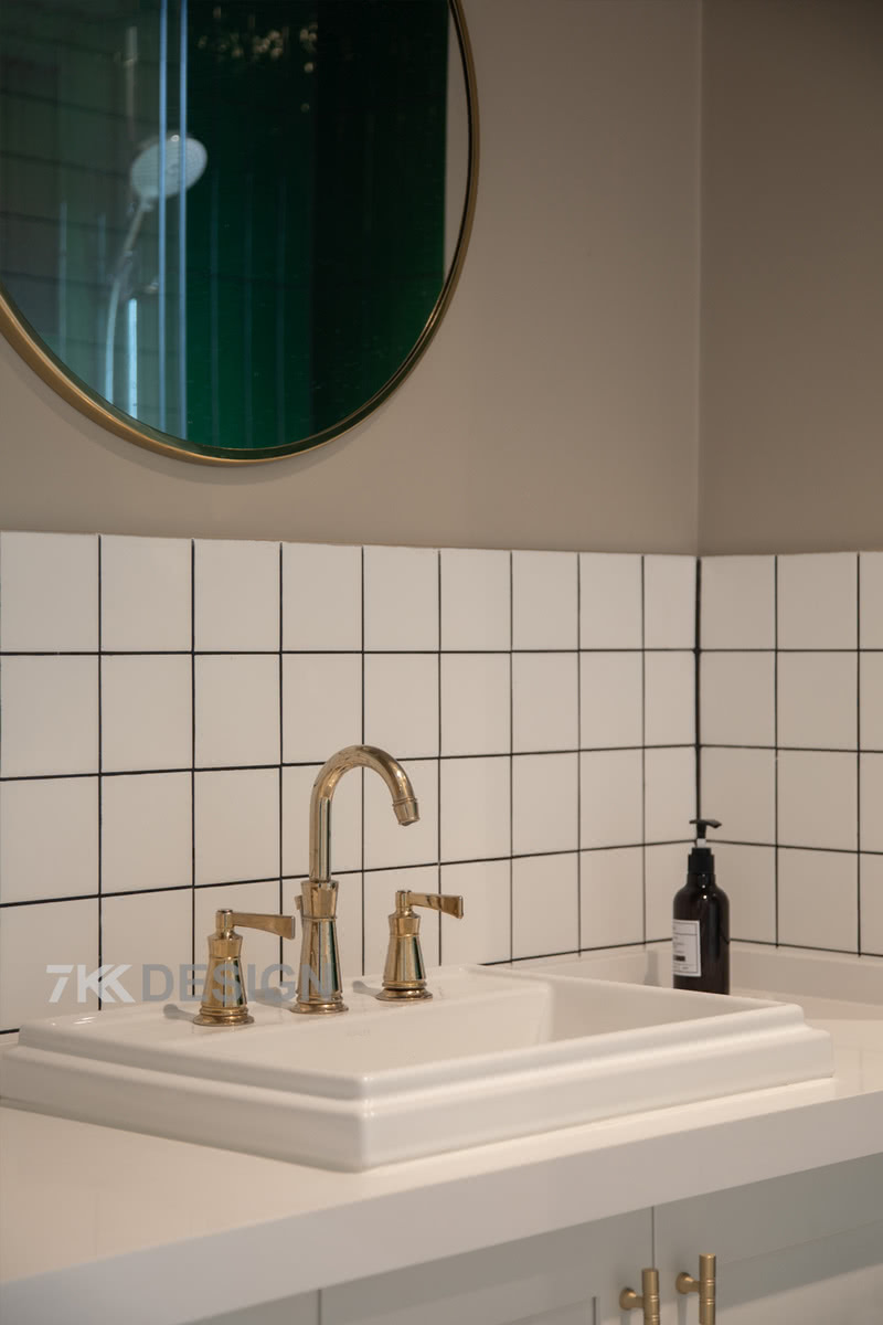 经典简洁的小白砖，金色边框的浴室镜，还有金色的水龙头与柜门把手点缀，将轻奢的氛围引入浴室，让卫浴空间变得更加精致。