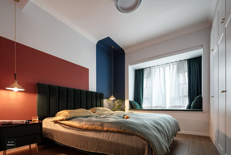 主卧的床头背景墙采用红色与蓝色的撞色设计，简约、干净的白色碰撞上诗情画意的蓝色，高调的色彩搭配，酝酿出复古雅致的格调。