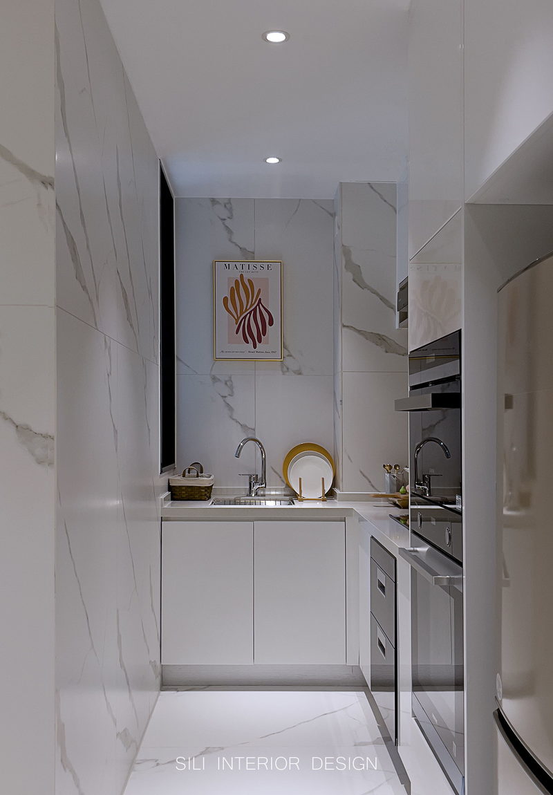 在一字型的厨房空间中，以白色为主色调很好地体现了整体的质感，凸显稳重大气；墙面地面都选用哑光的鱼肚白岩板，使整个空间看起来干净明亮。
