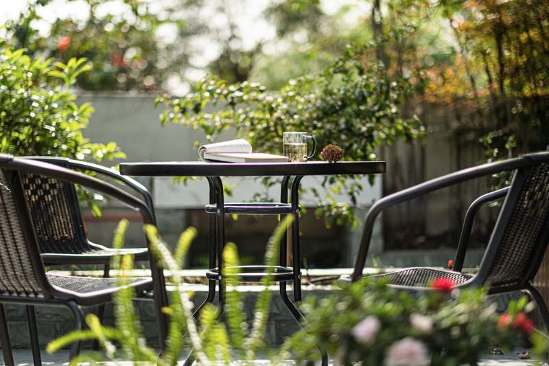 围绕在花园中的藤编桌椅，在闹市中取一片闲暇，惬意又满足。