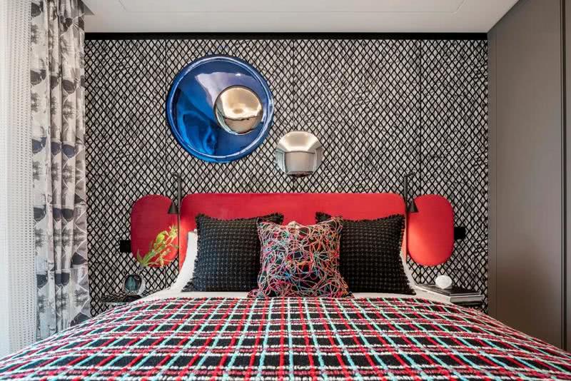 另一套次卧采用红蓝撞色设计，热情与平静的碰撞释放愉悦活力之感。圆滑流畅的弧线散布于床头柜、挂饰、床边柜、灯饰，流动而温柔的艺术线条完美勾勒出生活的舒适安逸。
菱格纹路的荷兰MOOOI定制墙纸不仅具有柔软触感，更赋予了空间奢雅格调，不同几何形状在室内自由叠加，又让空间绽放出优雅与个性。
真正的优雅不仅在于大空间营造，更在于细节。所有卧室的床品和织物运用了棉、麻、羊毛等天然材质，光泽柔和，凹凸的纹理带来生动的触感，柔软、滑糯，跟肌肤接触时带来舒心的熨帖。