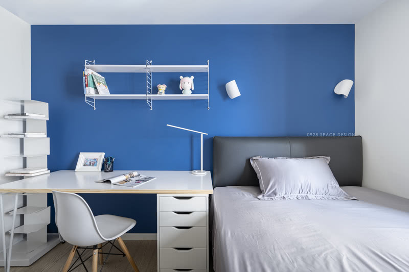 次卧一面蓝色背景墙，给整个空间增添了几分鲜活，很好地避免了房间低饱和度的家具过于单调沉闷。