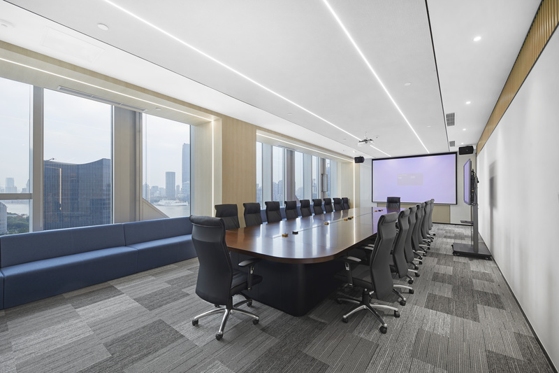 会议室延续公共空间的木饰面材料，以保证空间的连续性，而通过使用不同的材料比例让空间区分开来，木饰面的运用让会议室庄重感更强。