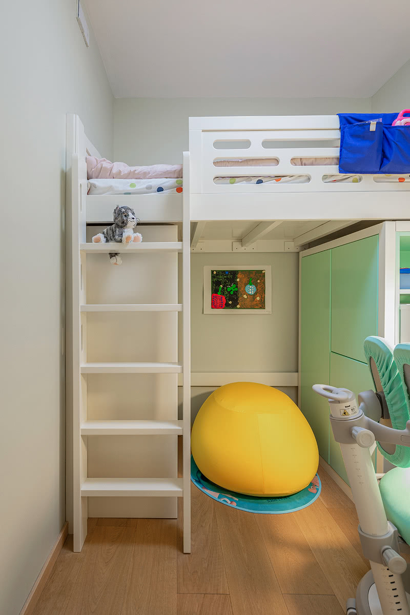 儿童房采用上下铺是设计，下面两侧是收纳衣物的柜体，床架大面积是白色，柜门使用了嫩绿色作为衬托，在色彩设计手法上使得空间更明亮、清新、宽敞；同时中间的鸭黄色泡沫圆垫为这个空间增添了丰富的色彩。