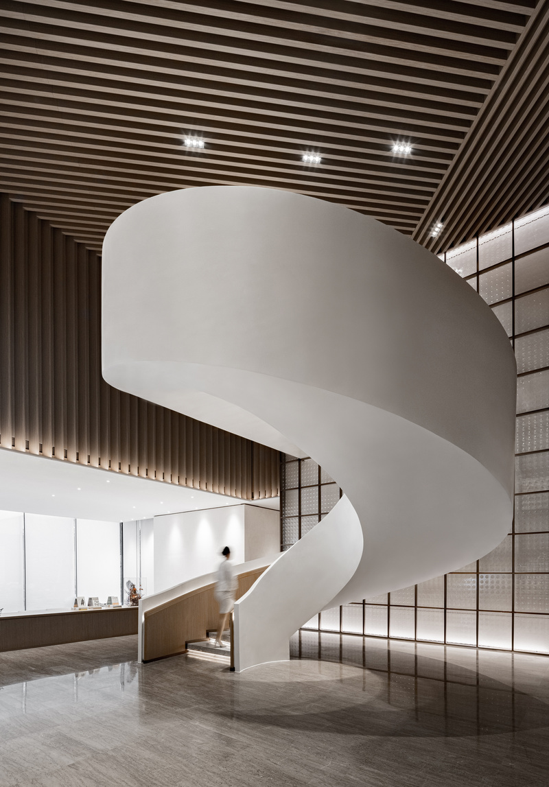 一部白色螺旋楼梯占据中厅核心，如同雕塑般瞩目，彻底打破了方形格局，成为空间中生动的立体主义艺术。螺旋楼梯有力且柔美，无论自上而下还是自下而上都能感受到几何美学和流线韵律。