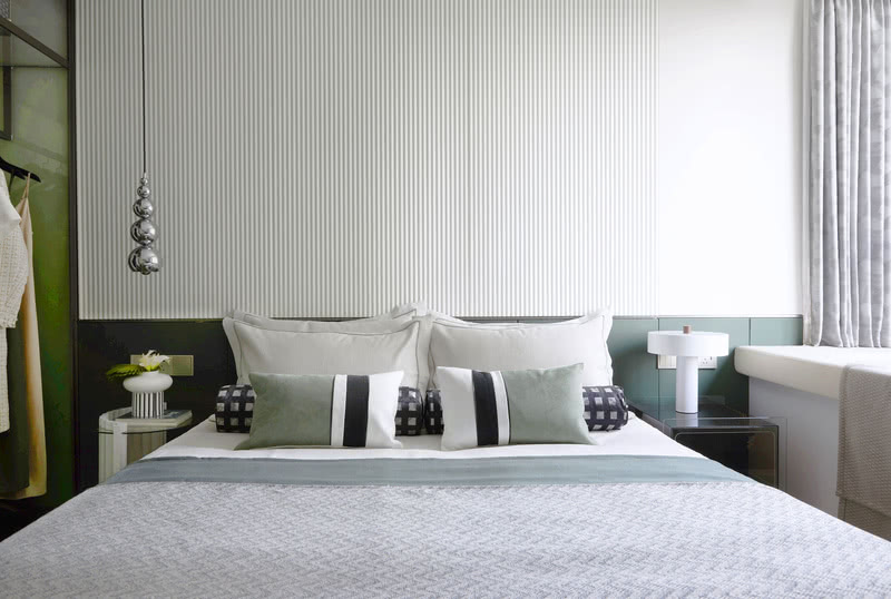 主卧空间以绿灰色系为主题色，营造舒适自然的休憩氛围。