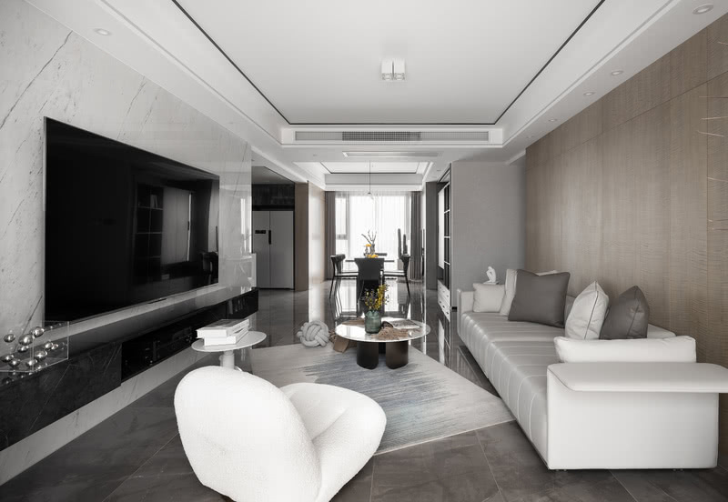 灰色奠定空间宁静的基调，
米白色意式沙发同色系的单人沙发
与大理石纹茶几与整体氛围和谐共生，
绿植、摆件...以细微处的变动打破沉闷，光影穿梭于室内，
与纯粹的木色一同展现出惬意安然的姿态。