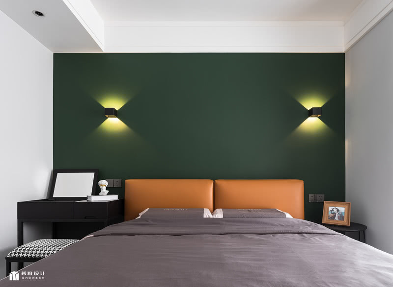 床头背景就是采用墨绿色墙漆，搭配两个造型壁灯，简洁、清爽。