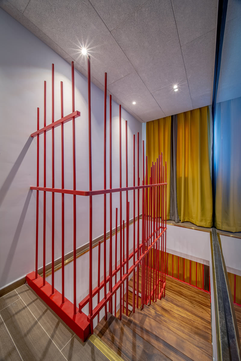 设计师将楼梯护栏用了一个非常经典和传统的红色，做成了参差不齐的篱笆形状，红色是非常挑装修风格的一个颜色，一旦风格不搭，视觉上就会非常的土气。为客户解决问题才是客户想要的结果，所以我们的设计师在整个空间当中选择了白色作为空间主要的色调，让空间变得更加简约精致。