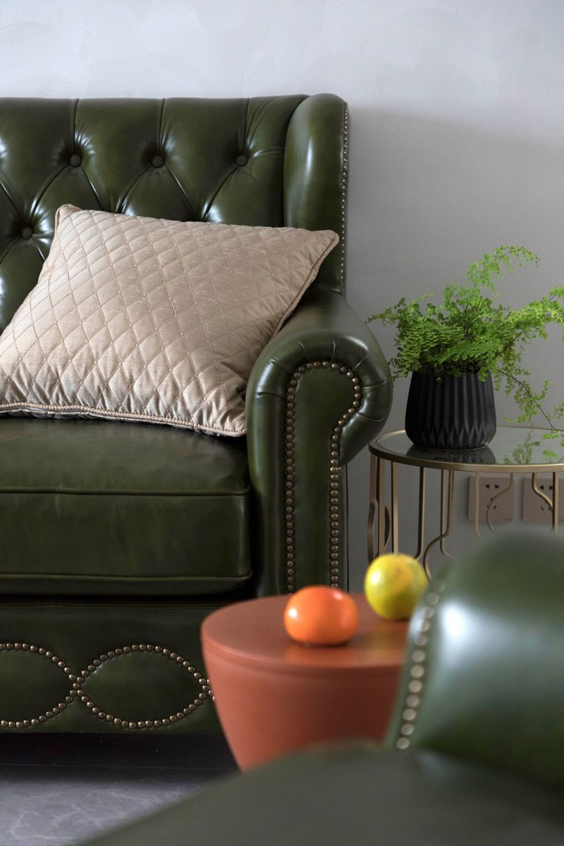 客厅软装搭配十分讲究，灯具、茶几与绿皮沙发的气质相互融为一体。