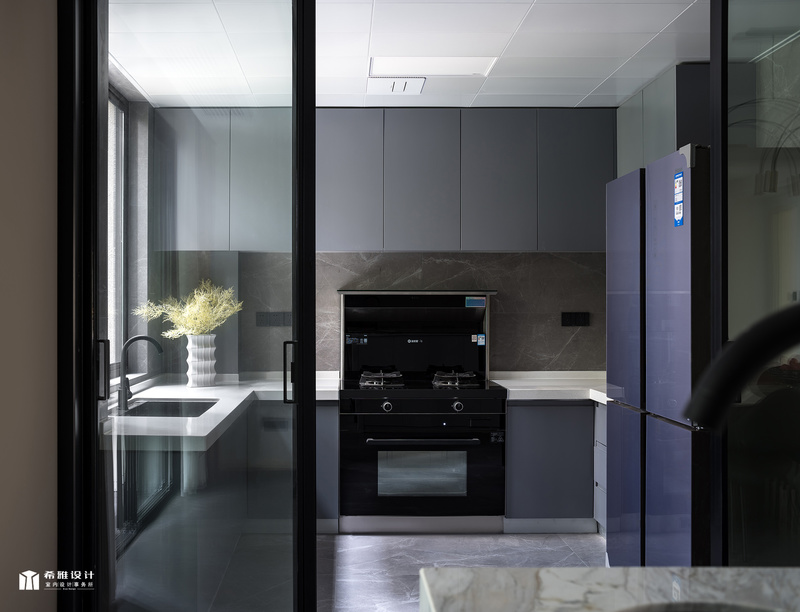 厨房是一个家的核心，要操作方便，也要有气质，因为厨房面积够大，做了U字型的台面后，还能摆上双门冰箱，浅灰色的橱柜门搭配柔光墙砖，给视觉带来了舒适的感受，让空间有一种优雅的气质。
