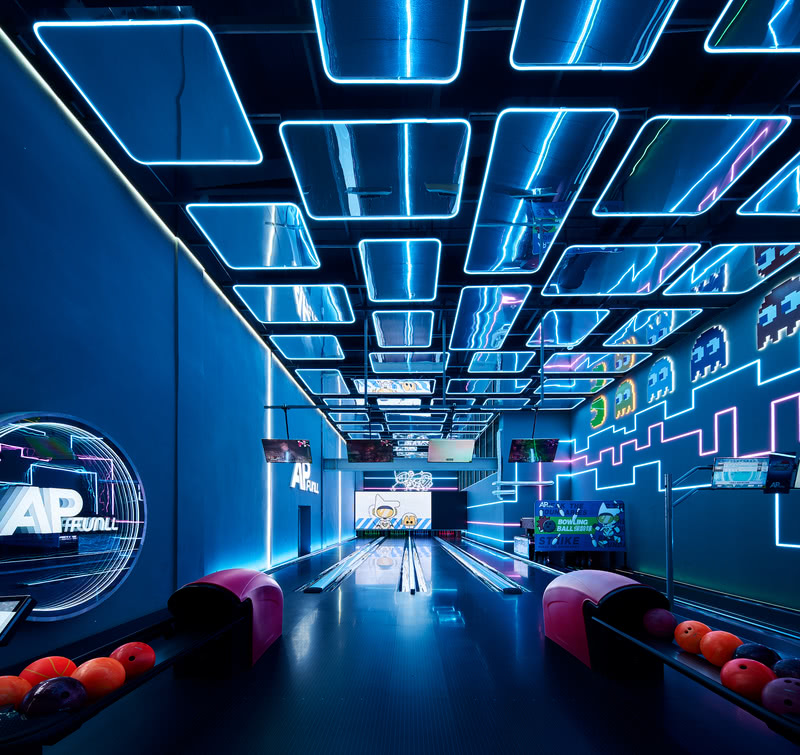 龄球场大面积地使用凉爽的蓝色和紫色线霓虹灯，使空间更富有电子科技感。

The bowling alley uses cool blue and purple line neon lights in a large area, making the space more electronic and technological.