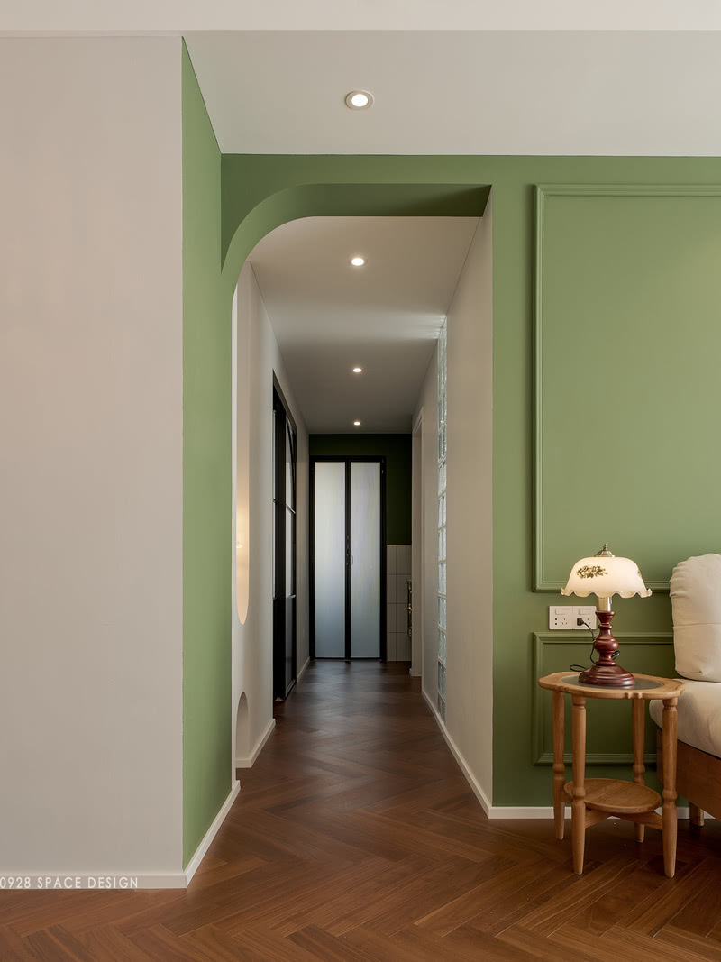 走廊以半弧门洞和松林绿的背景墙作为开端，主卧玻璃砖透出来的光提亮了走廊，更显通透。