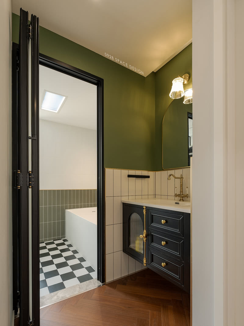 松林绿的乳胶漆半墙拼白色方砖，搭配黑色的浴室柜更显质感，特意挑选的水龙头让复古感拉满，洗手台下方镂空无卫生死角。