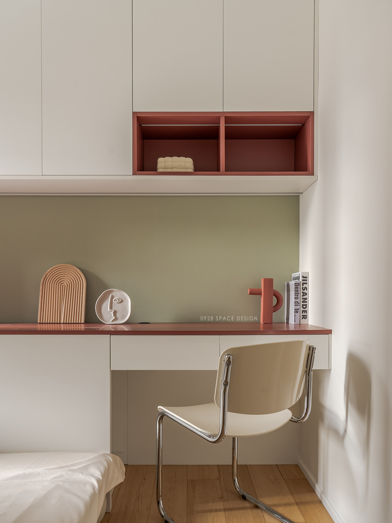淡绿的背景墙与砖红的面板拼色，让书桌和书柜的镂空更有设计。细腻圆润的白色亚克力单人椅，简而不简单，为空间提升质感。