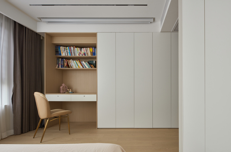 床位的是衣柜和书柜的一体设计，书柜的木色丰富空间的色彩感。天花设计了隐藏式的投影幕布，休闲时刻观影模式随时开启。