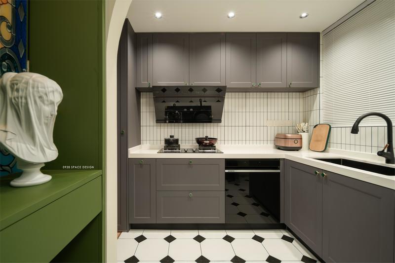 原厨房墙体拆除，做半开放式，L型的料理台烹饪动线方便，碳灰色的哑光烤漆让厨房硬朗中不至于过冷，黑白拼接的地砖为玄关和厨房的空间增添几分复古感。