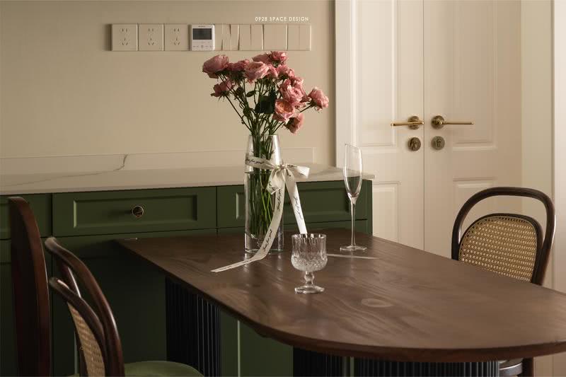 餐桌采用了极简精致的半圆设计，给人一种优雅又别致的感觉，在玫瑰与玻璃杯的映衬下，增添了一丝生机和自然，整体呈现着一种独特而精致的美感。