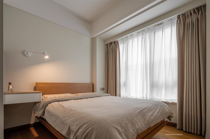 次卧与主卧的格调一致，木质家具搭配低饱和的奶茶色床品和窗帘，整个空间柔和恬静适合休息。
