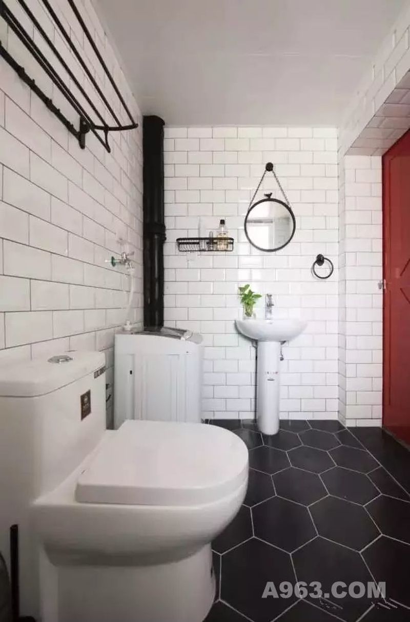 ▲ 谷仓门的运用，让卫生间的实用空间变得更大，白色的墙砖搭配黑色的六边形地砖，很有北欧特色，清爽、明亮给你每一天的好心情。