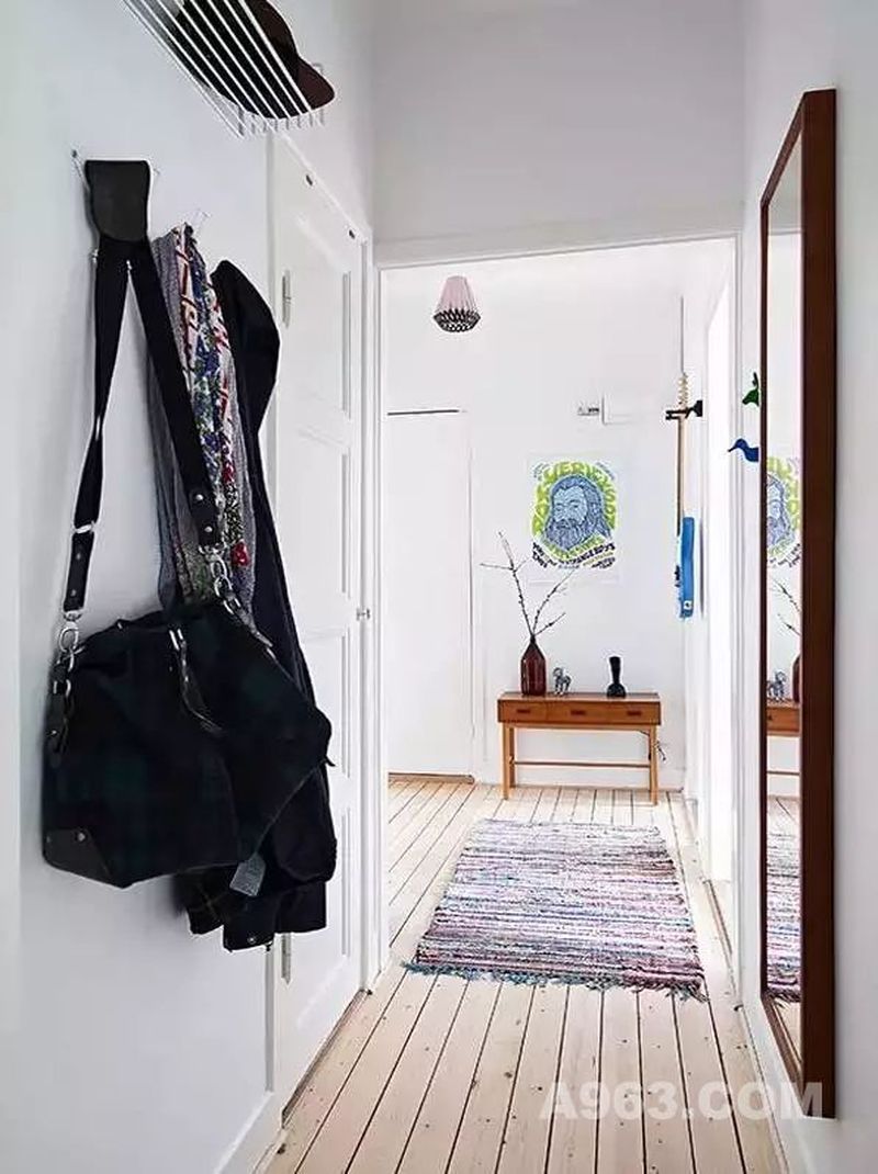 ▲ 进门是一个小走廊，在墙上添置几个挂钩和隔板，就有衣服和包包的收纳宝地。大大的穿衣镜带来了充足的采光，也丰富了玄关的功能。