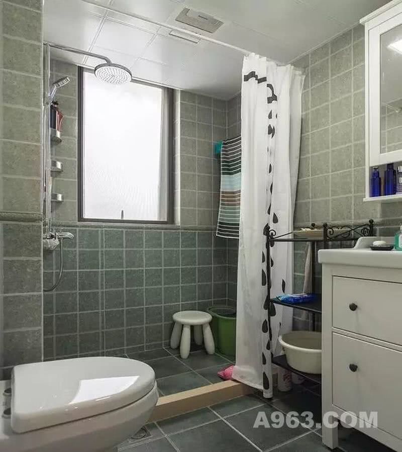 ▲ 卫生间用深浅不一的绿色墙砖铺贴，让单调的墙面变得很有层次感。用浴帘划分出淋浴间，干湿分离，方便实用。