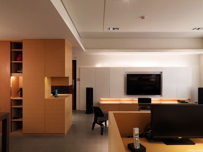 在客廳與工作空間當中不採用格間區隔開來，設計師採用矮木牆讓空間呈現開放與連成一氣的感受