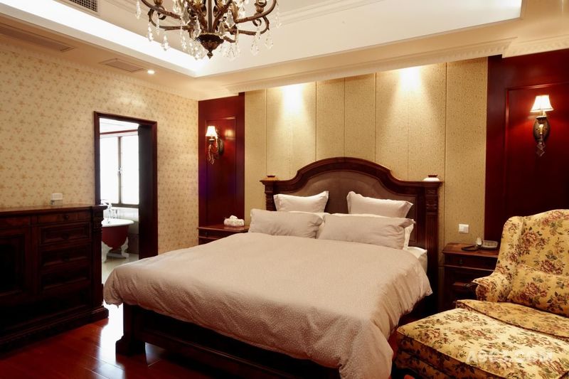 主卧室色调明亮、典雅，以米黄色及驼色为主调，渲染温馨、舒适的睡眠氛围