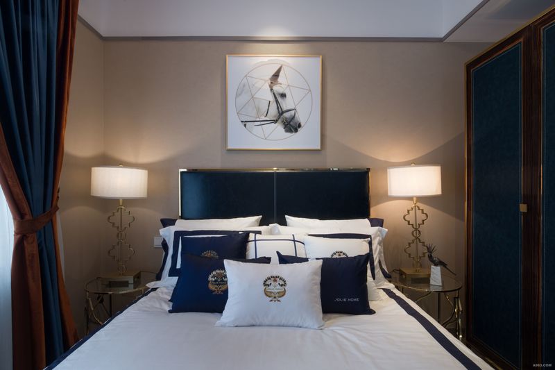 主卧室中设计师以中性咖啡色作为空间底妆，给人以轻奢宁静的质感。主卧室双人床的皮质床背质感温润，金色线条走边，与墙面上的艺术挂画相得益彰。