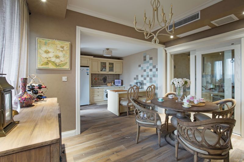 做旧的实木餐柜具有强大的收纳功能，墙上的创意造型，让空间又多了一抹设计的味道。餐厅和厨房做到了同一个大空间中，西厨吧台设计很精巧，为房主的居家生活提供的很多便利。