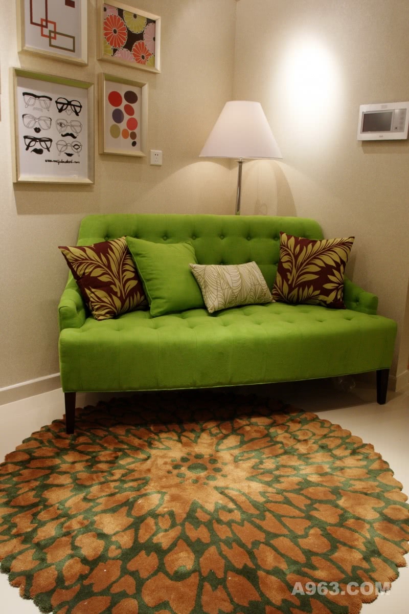 闲情雅致
该户型属于小户型的复式公寓，在整体布局上运用了灵活性的功能布局与弧型线条的傢俬。线条的律动在小空间里制造出轻松愉悦的氛围，苹果绿沙发独隅一角聚焦客厅的视觉焦点，花朵造型的地毯则开放出绚丽多彩的生命气息，让整个空间充满无限活力与动感。绿色是具有生命力的象征，带来一股清新、自然而健康的气息。空间中绿色与米色的对比，衬托出简约舒爽的感觉。时尚感强烈的现代傢俬、绿色纹样的窗帘、动感纹路的墙纸之间的搭配，以动静相宜的结合姿态为空间增添出一丝韵味，而时下流行的色块挂画更是该空间的个性化语言。