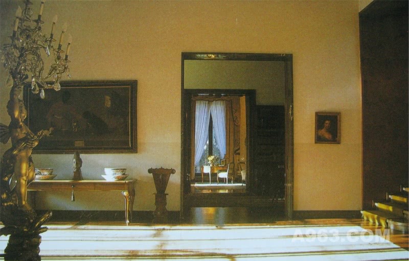 中庭角度2
这个角度的欣赏到的中庭展示了旧家具和空间的并列和衔接，这是1930年典型了米兰建筑设计风格，并被古典主义所采纳，中庭内摆放着这张18世纪的桌子旁边是两个托斯卡纳的文艺复兴时期的
凳子，被放在了最显眼的位置，巴洛克式热那亚底座和支撑结构则则被用作吊灯。
