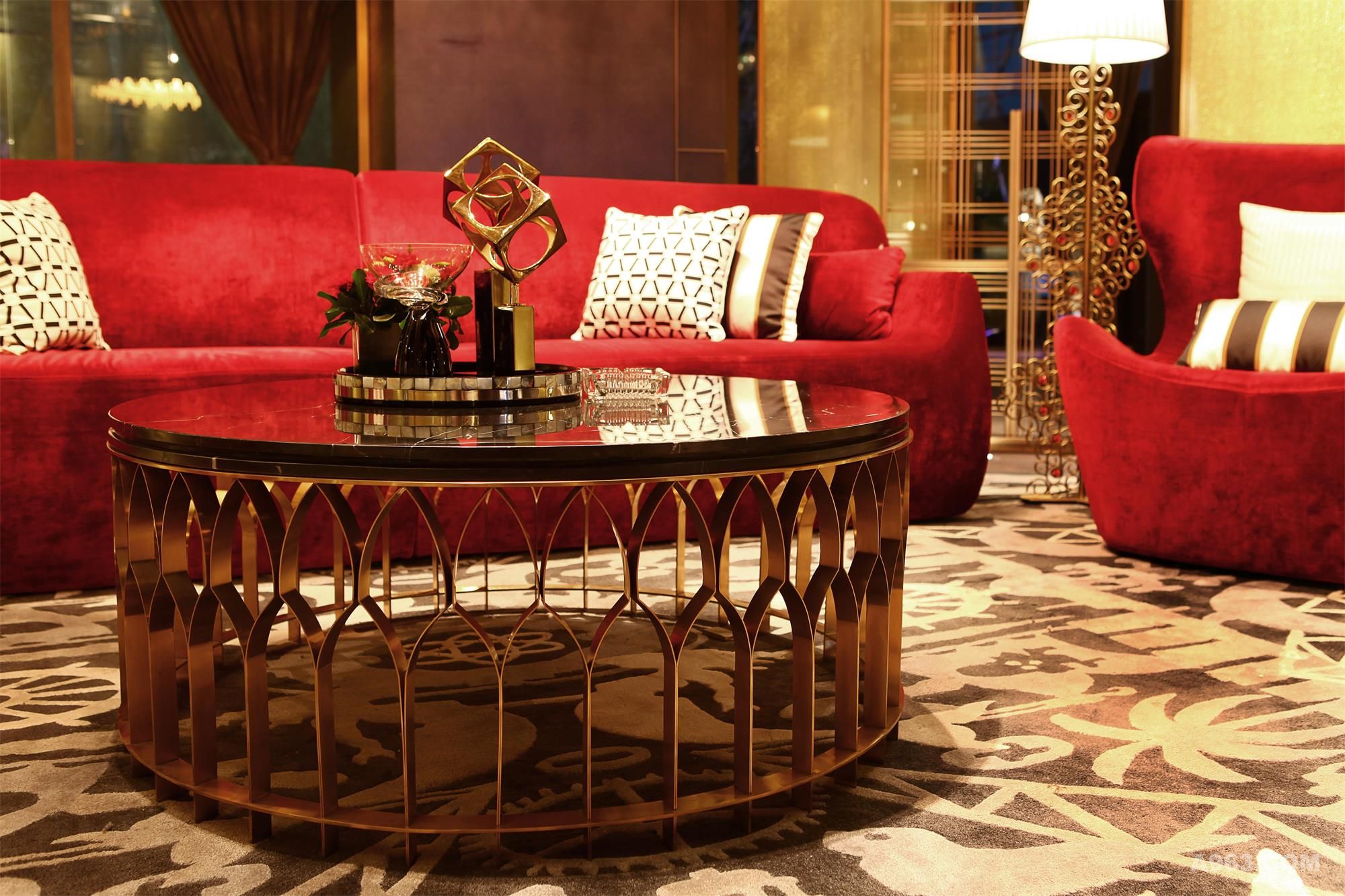 热情艳丽的大红色沙发，搭配玫瑰金色桌台，红色的绒面、玫瑰金色的金属，看似毫无关联，搭配起来却丝毫不违和，颜色与材质的碰撞成为别具特色的组合
