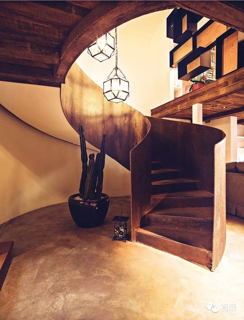 通往二楼的弧形钢板楼梯，以其灵动的造型，让你以优雅的姿态步入设计师工作室。二楼的隔断以大小不一的铁艺框和木板结合而成，赋予空间通透感。