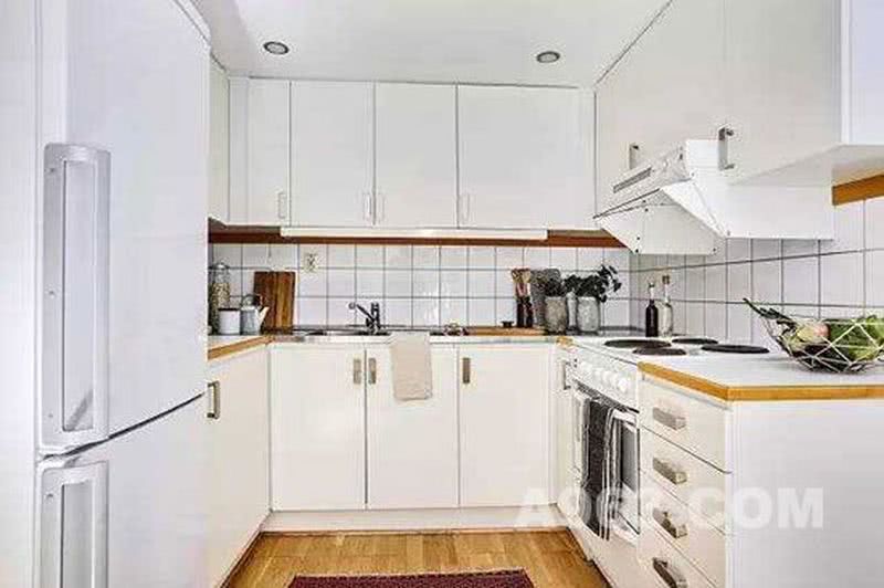 厨房是半开放式的，比起完全开放的厨房来说能更好的阻挡油烟。白色的厨柜和橘色的地板，让厨房看起来更加干净温暖。
