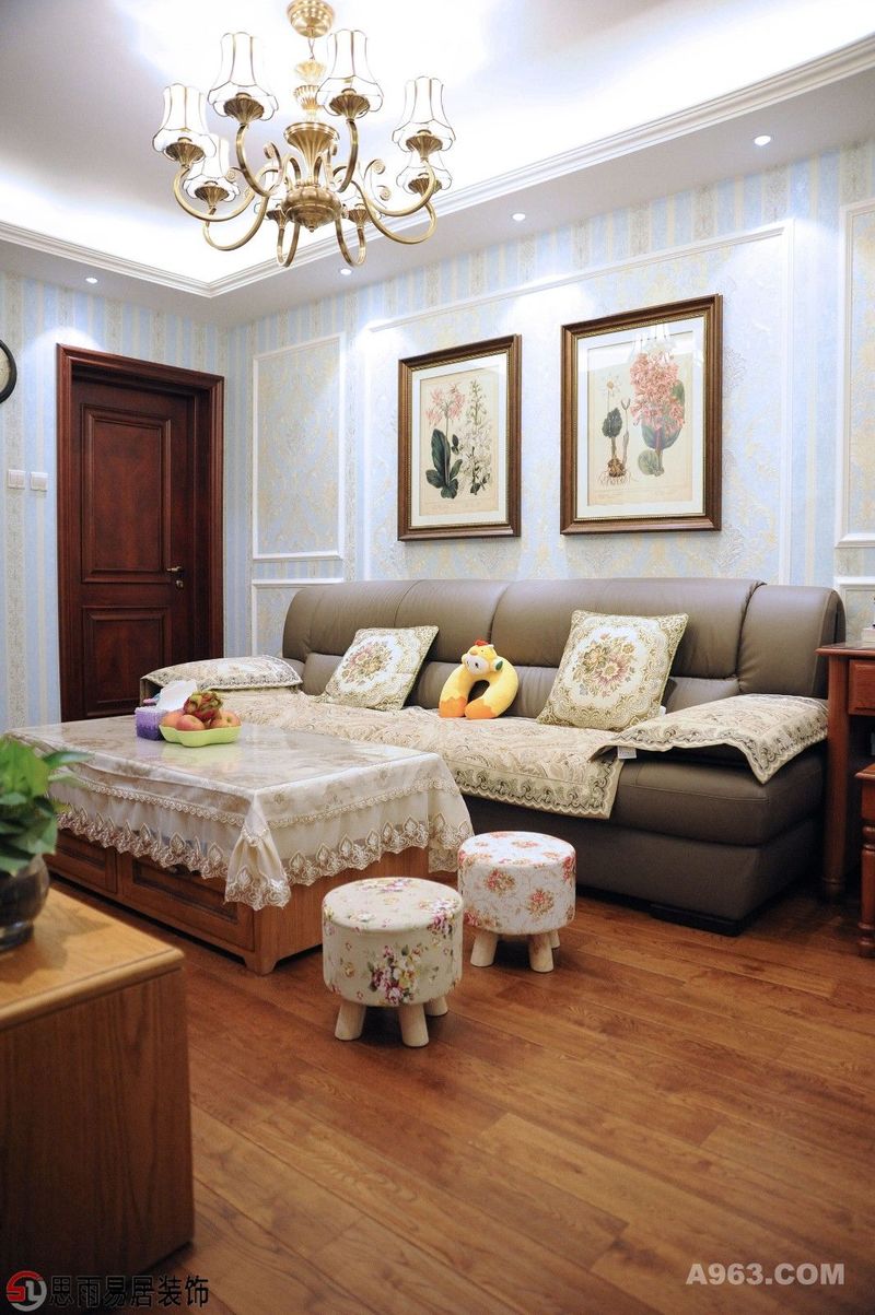 客厅作为待客区域，一般要求简洁明快，同时装修较其它空间要更明快光鲜。黄蓝相间的碎花美式壁纸，原木地板和家具，再搭配富有美式元素的铁艺吊灯，让客厅散发出温馨，柔和的家庭氛围。