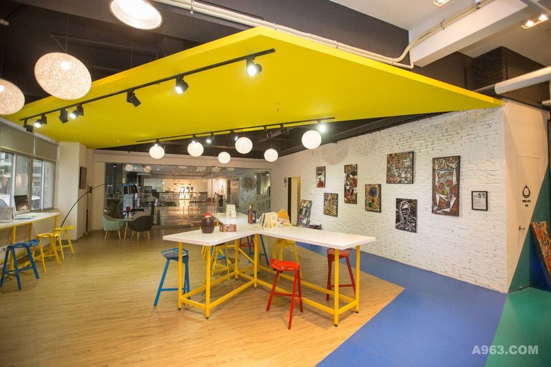 前厅区域位于蓝色和黄色之间，配有各种家具。营造一种纯粹而简单的气氛，与城市完美契合。街头艺术画作与白砖成了办公室里一道独特的风景线。