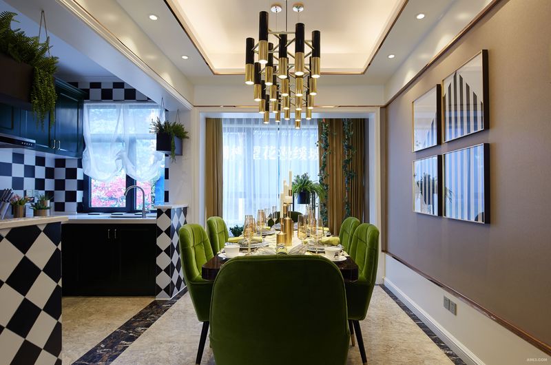 客餐厅实景图 : 
从餐厅看向厨房，黑白棋格墙面，搭配着祖母绿的橱柜，释放着戏剧化的视觉冲击力。黑白几何条的金框挂画，更增一分国际范。 