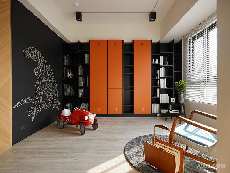 橘色的收纳柜让空间增添活泼，也象征着屋主热情开朗的性格。
而一旁黑板漆的墙面，可供小孩自由涂鸦，让空间是可以随着时间一点一滴留下印记。
