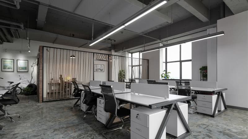顶部保留原有结构，灰色漆和水泥地面搭配白色办公桌面，黑色办公桌支架和黑色办公桌椅与黑色的隔断框架色彩统一。整个空间采用黑白灰三色为主色调，简单统一。