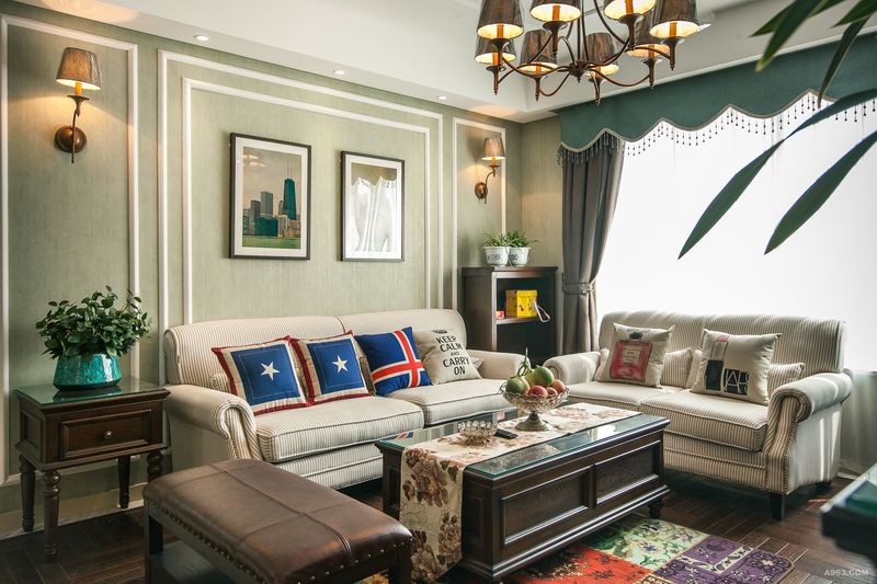 客厅沙发背景采用绿色墙面，白色装饰线的设计，自然而清新。再加上挂画与壁灯的装饰，使得墙面不显单调。