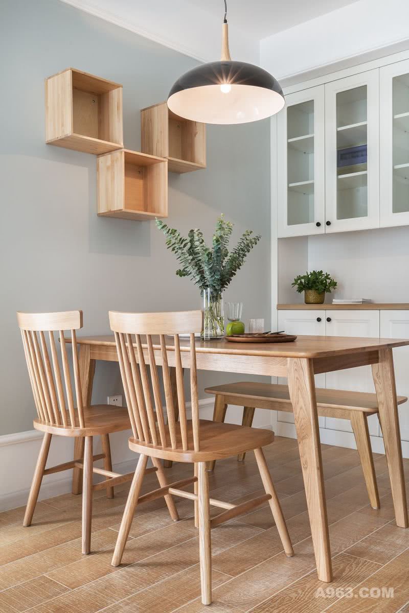 原木色的餐桌、餐椅与同系列的长凳搭配使用，为空间增添温暖感，白色的入墙式餐边柜，可以满足日常收纳的需要。