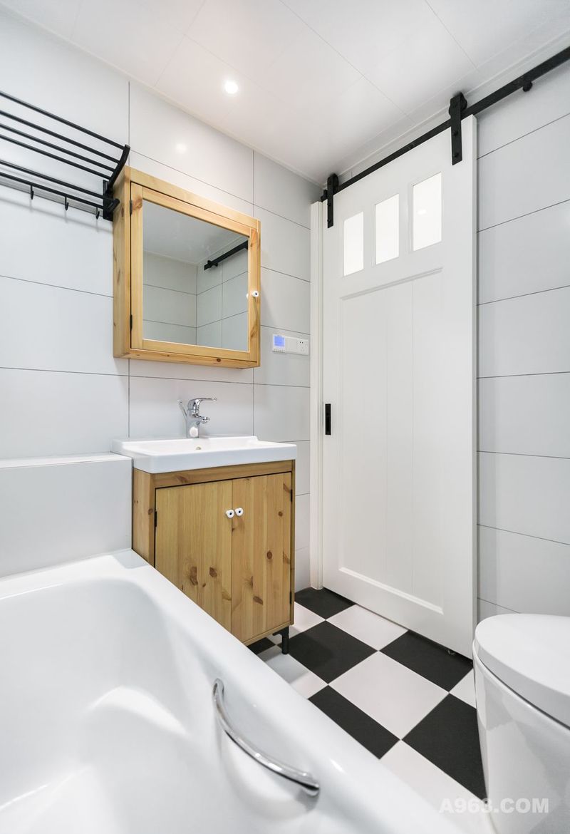 卫生间以白色为主，白色墙面、黑白格子地面搭配原木色浴室柜，简洁清爽。