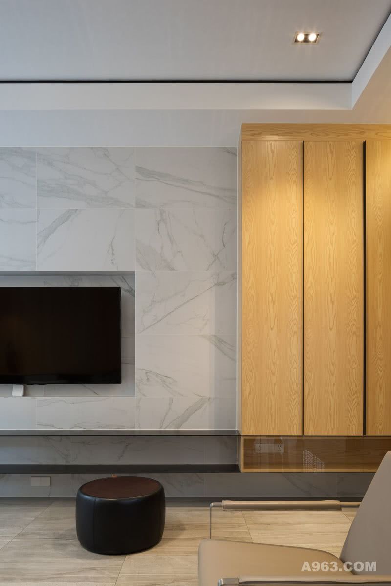 ▶客厅去除了复杂的修饰，让空间变得更加开阔。为了不让简单的空间显得苍白，沙发背景墙选用了实木质感的饰面板来铺设，木质地板在视觉上形成层次感的同时，还与之呼应。木纹让整个空间都多了些许温柔感。
