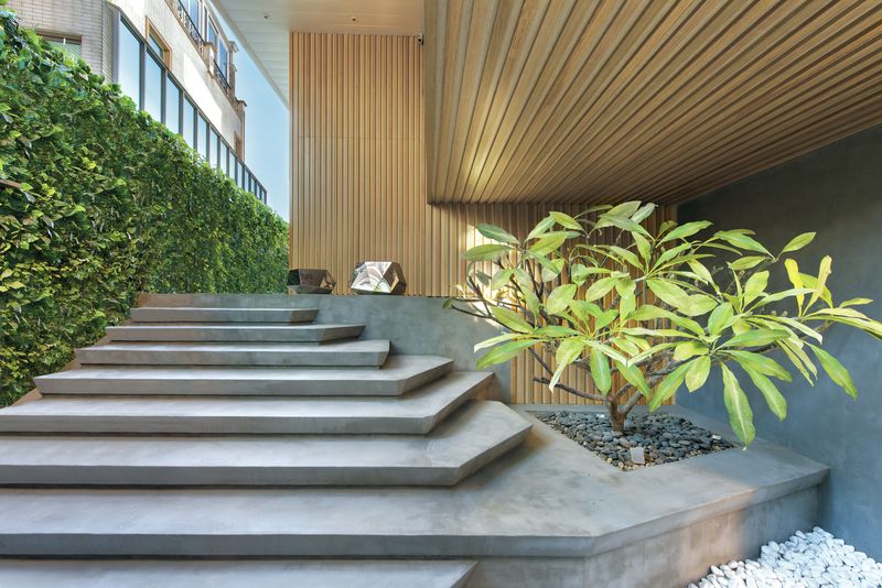 设计师特意将玄关位置的楼梯设计成石板形状，配衬两张金属切面矮凳。