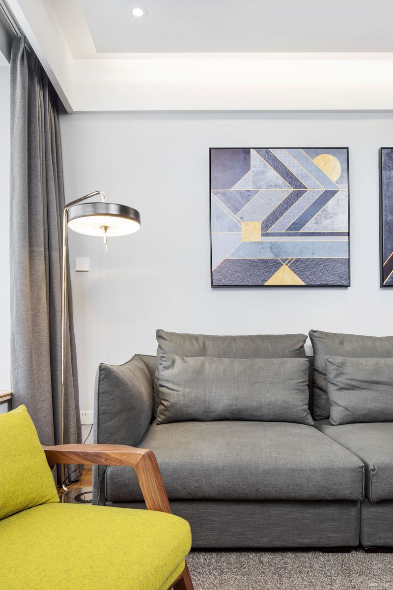 在素雅的暖灰调沙发背景墙中，搭配抽象感的北欧几何装饰挂画，在璞素的氛围中透露出一种都市现代休闲生活空间的感觉。