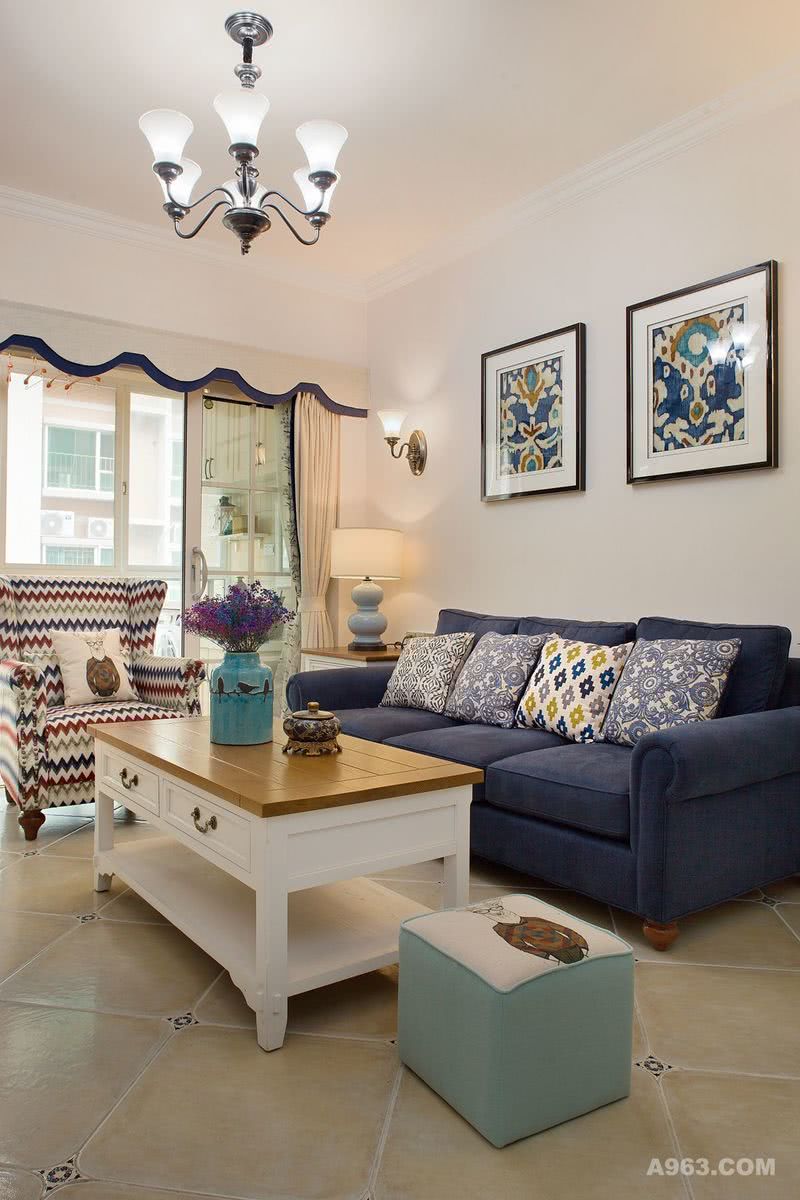 蓝色的沙发与杏色调的客厅相配；
沙发背景设计壁灯，并用两幅挂画装饰