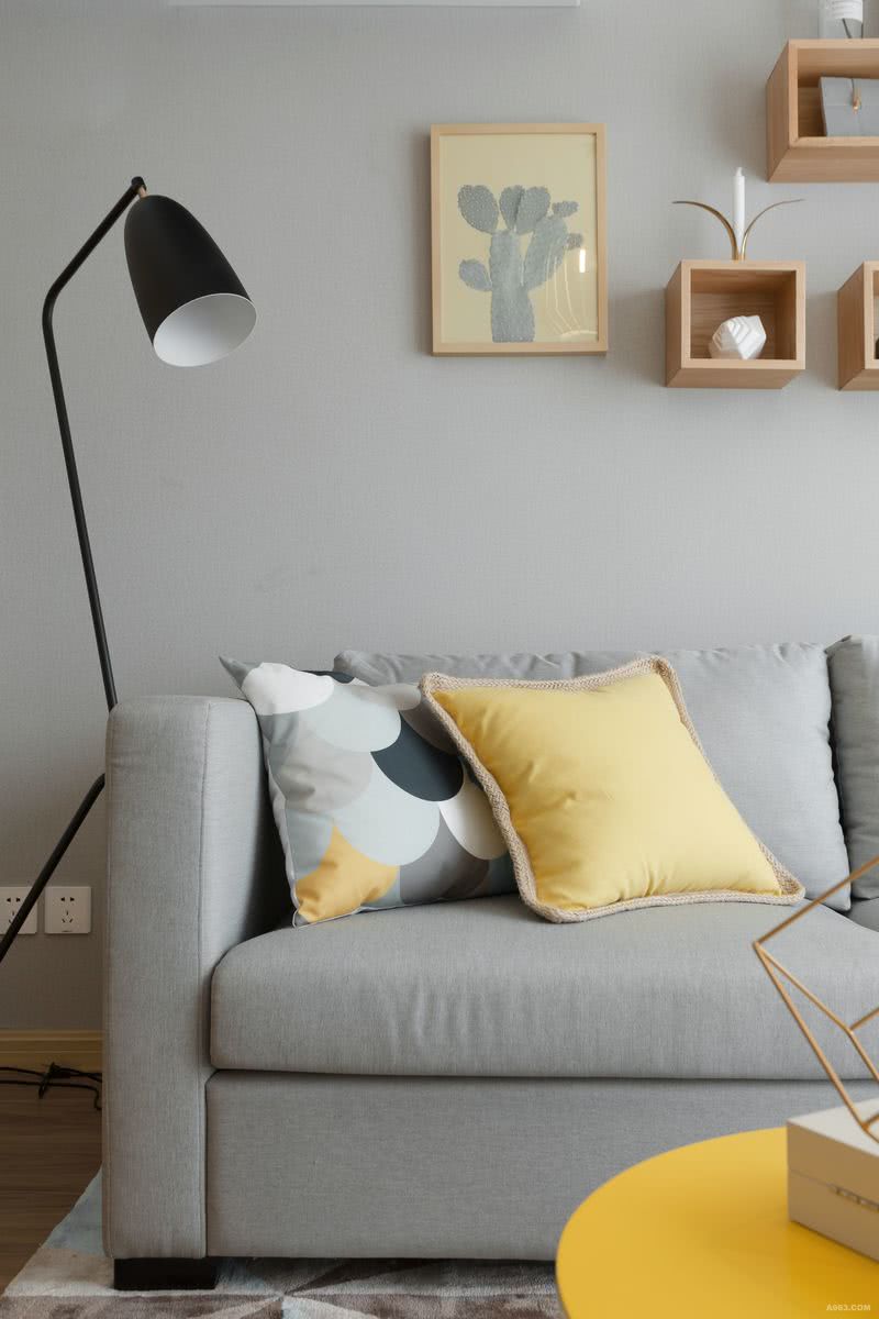 灰色布艺沙发搭配明黄色抱枕。